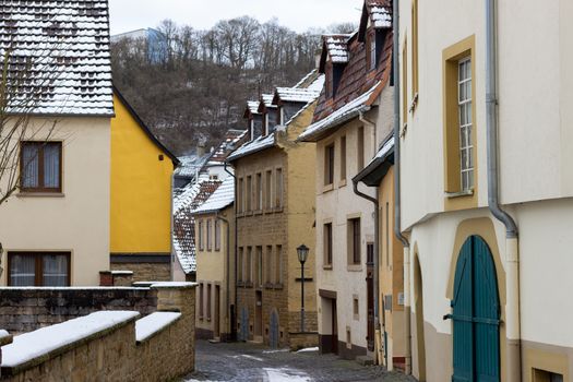 Cobbled narrow alley in the historic old town of Meisenheim, Germany in winter with snow