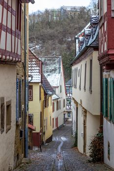 Cobbled narrow alley in the historic old town of Meisenheim, Germany in winter with snow