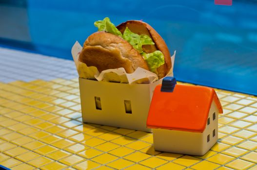 Freshly made burger fast food with soft toy orange house model