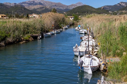 Boats at both sides of a stream in Port d' Andratx, Mallorca with mountain range in the background