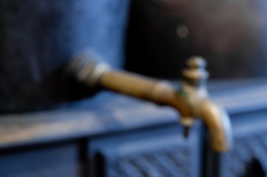 Defocused blurred golden brass old vintage water tap