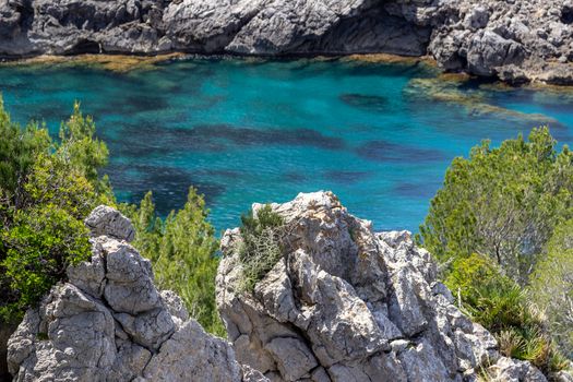 Bay Ses Caletes on the peninsula La Victoria, Mallorca with rocky coastline and turquoise clear water