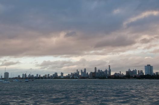 Wide angle evening scene of skyscrapers horizon with ocean and tall office and residential towers in Melbourne Australia