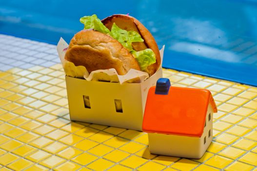 Freshly made burger fast food with soft toy orange house model