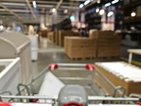 Defocused blurry scene of self service furniture warehouse shop with a cart
