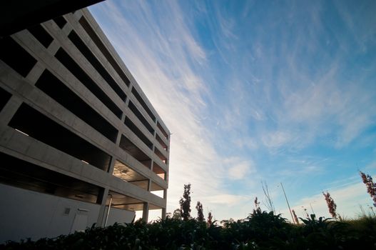 Empty vacant car parking building with blue sky and local garden