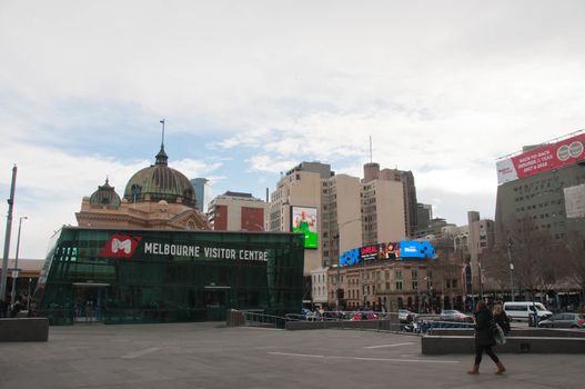 MELBOURNE, AUSTRALIA - JULY 29, 2018: Melbourne Visitor Centre situates in Federation Square near Flinders Street station in Melbourne central business district. There are people sitting and walking in the square. The photo is taken in the afternoon.