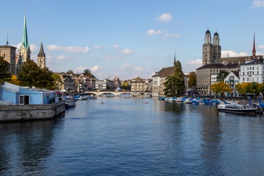 view at the waterfront of Limmat river in Zurich, Switzerland with ships, churchs and other buildings