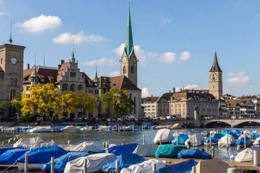 view at the waterfront of Limmat river in Zurich, Switzerland with ships, churchs and other buildings