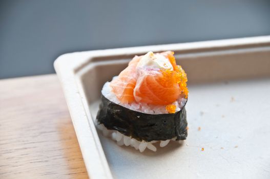 Golden orange fresh tasty raw Japanese salmon belly with cream and a hint of tiny shrimp eggs top up on sticky white rice wrapped with crispy seaweed