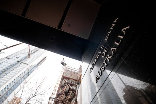 MELBOURNE, AUSTRALIA - JULY 26, 2018: Reserve Bank of Australia name on black granite wall in Melbourne Australia with a reflection of high-rise buildings. The RBA building is located at 60 Collins St, Melbourne VIC 3000 Australia.