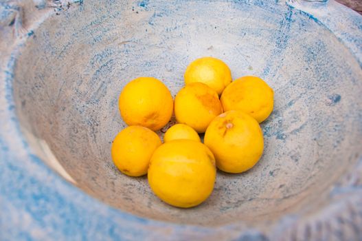 Many yellow fresh lemon from farm in vintage stone bowl