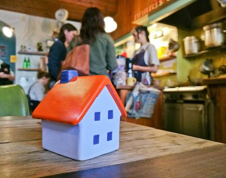 Little tiny soft toy house model in a cosy restaurant