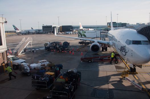 MELBOURNE, AUSTRALIA - JULY 26, 2018: Virgin Australia plane parks and luggages are offloaded at Melbourne airport