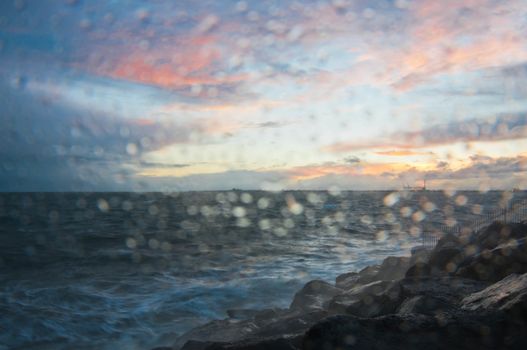 Dramatic splashing ocean wave in the evening with twilight sky in Winter at breakwater at St Kilda pier in Melbourne Australia