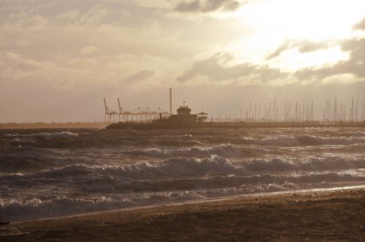 MELBOURNE, AUSTRALIA - JULY 29, 2018: Dramatic golden light ray from the sky in the afternoon with St Kilda pier and windy ocean in Melbourne bay and high tide wave. Nobody is in the photo.