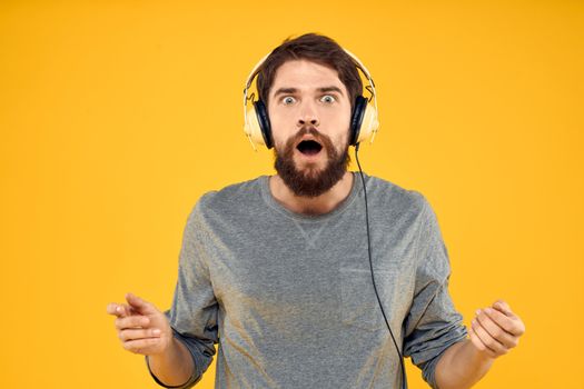 Man with headphones music lifestyle lifestyle technology yellow background. High quality photo