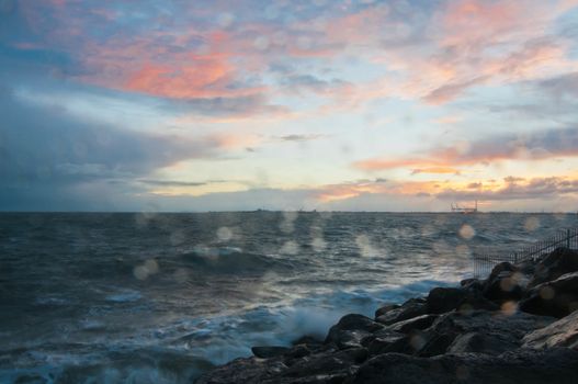 Dramatic splashing ocean wave in the evening with twilight sky in Winter at breakwater at St Kilda pier in Melbourne Australia