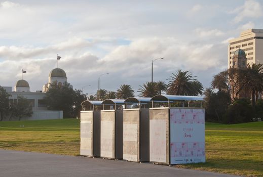 MELBOURNE, AUSTRALIA - JULY 29, 2018: Four stacks of Melbourne city councils metal bins locates near St. Kilda pier in the afternoon near a clock tower. The bin has a print out graphic says "ST KILDA IS FOR Icons". There is nobody in the photo.