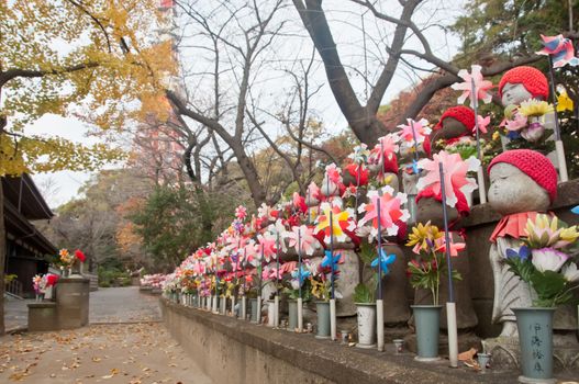 TOKYO, JAPAN - DECEMBER 1, 2018: Scene of wind turbine papers to worship souls of children in the back park of Zojo-ji Buddhist famous temple built from 1622. There is nobody in the photo. There is Tokyo Tower nearby the temple.