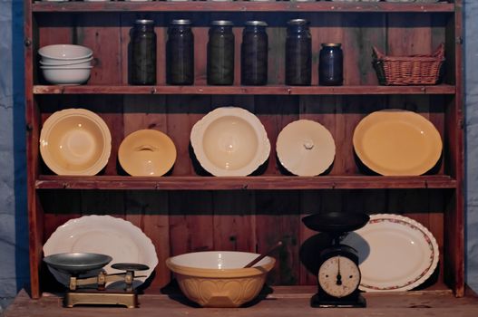 Vintage kitchenware and utensil on brown wooden cupboard in a house