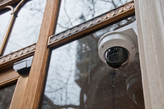 Surveillance CCTV security dome camera near office window in Europe
