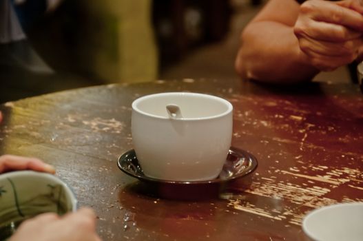 An empty bowl of famous hot and cold sweet dessert soup in a round table with her friend in Hong Kong restaurant cafe