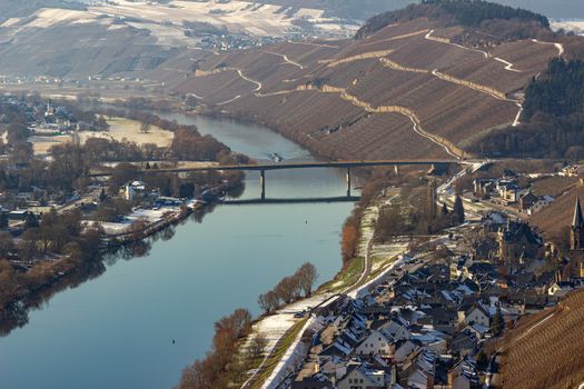 View on the valley of the river Moselle and the wine villages Mülheim and Lieser, Germany in winter with snow