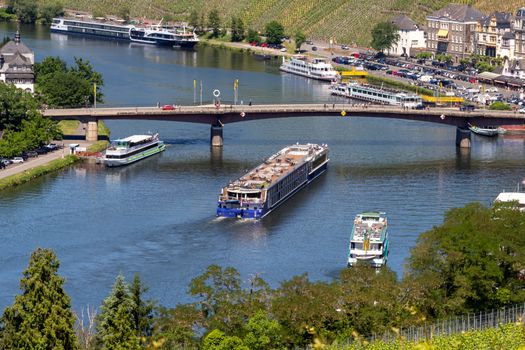 View at the valley of the river Moselle and the city of Bernkastel-Kues, the Moselle brigde and many passenger ships