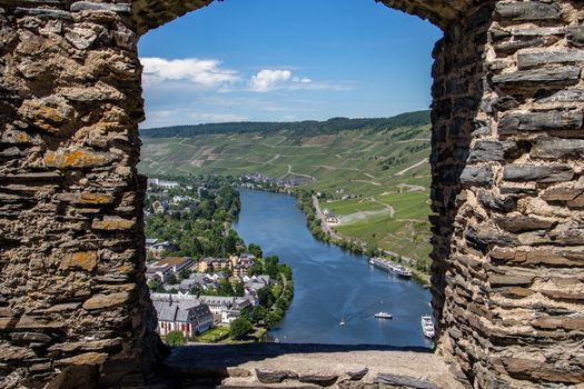 View at the valley of the river Moselle and the city of Bernkastel-Kues from Landshut castle through a window in the wall