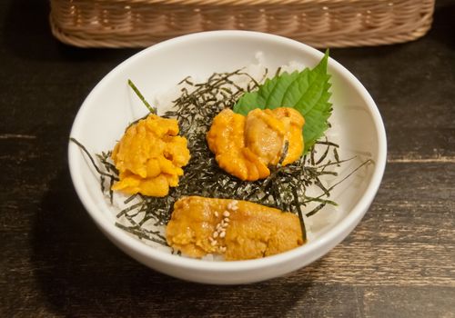 Premium supreme delicious fresh from the sea 3 types of uni sea urchin sashimi from Tokyo, Mexico, Canada on top of warm steamed rice with crispy grilled seaweed.