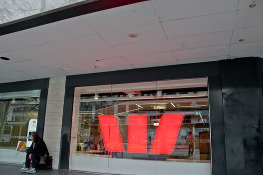 MELBOURNE, AUSTRALIA - JULY 26, 2018: Homeless man sits in front of Westpac bank in Melbourne Australia