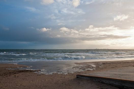 Beautiful blue cloudy sky with strong high tide wave of sea ocean creep to golden beach and wooden pavement in Melbourne Australia