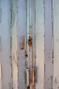 Old vintage classical metallic strong folding gate of front door of a house with a lock pad