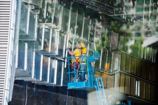 HONG KONG, HONG KONG SAR - NOVEMBER 18, 2018: Unidentified technicians wearing safety helmets standing on a lifter to inspect construction site.