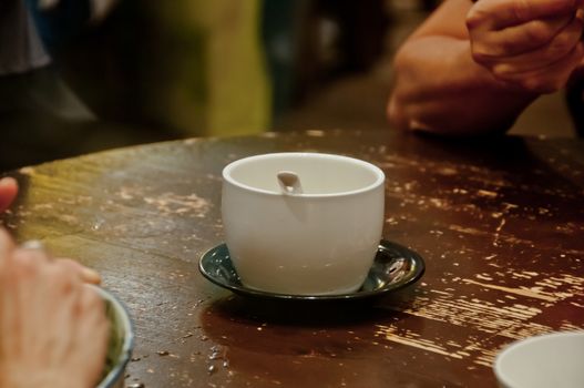 An empty bowl of famous hot and cold sweet dessert soup in a round table with her friend in Hong Kong restaurant cafe