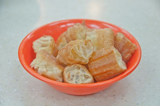 Fried sticky crispy golden traditional classical delicious yummy Chinese donut served in a small bowl