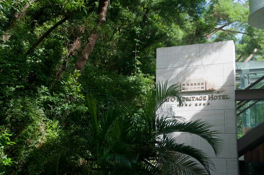 HONG KONG, HONG KONG SAR - NOVEMBER 18, 2018: Charming old classical vintage Tai O Heritage hotel situates in Tai O village in Hong Kong. The entrance of the hotel has big white stone name with lush green forest. Nobody is in the photo.