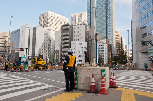 TOKYO, JAPAN - DECEMBER 1, 2018:  Japanese construction workers stand to wait for traffic light before crossing the road near construction site in the morning.