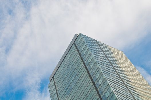 Tall majestic grand big modern corporate headquarters office with blue sky and cloud in the morning