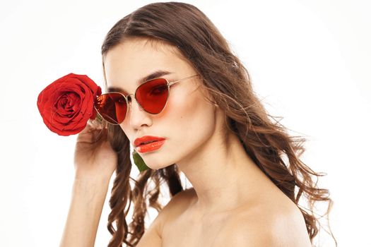 Brunette girl with red rose and sunglasses naked shoulders. High quality photo