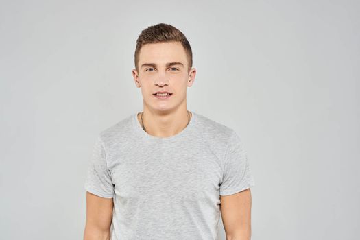 handsome man in light t-shirt cropped view emotion studio isolated background. High quality photo