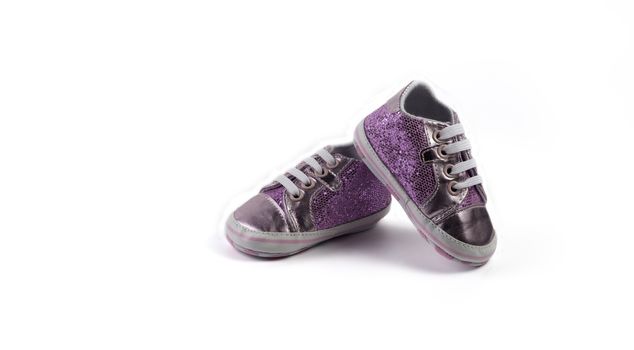 Children's sparkling little sneakers on white background.