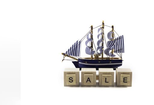 .Vacation tours sale concept - Small toy boat and inscription SALE