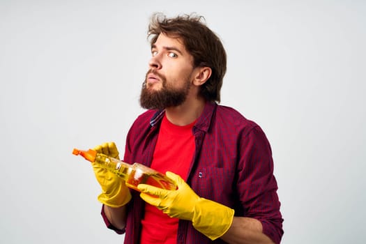 emotional man wearing rubber gloves detergent cleaning housework cropped view. High quality photo