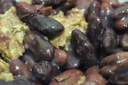 High angle close up picture of baked red kidney bean served with soup