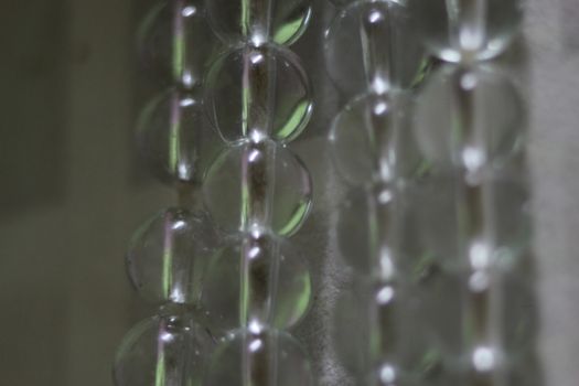 Macro photograph with selective focus of glass shiny prayer beads or rosary with copy space for text. Religion concept of ramadan or Eid for muslims.