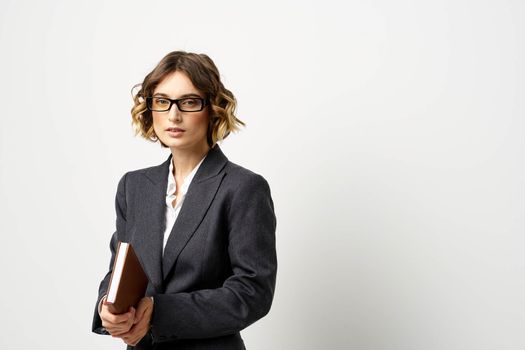 Business woman in a classic suit with a notebook in her hand and glasses on her face Copy Space. High quality photo