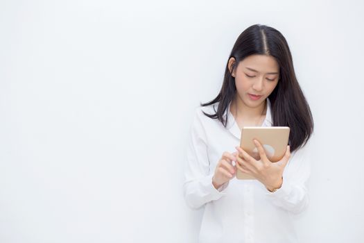 Beautiful portrait young asian woman using tablet computer cement background, businesswoman sitting looking tablet, communication concept.