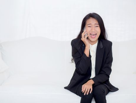 Beautiful young asian woman talking phone and smile in the living room, businesswoman sitting on sofa,businesswoman calling telephone, communication concept.